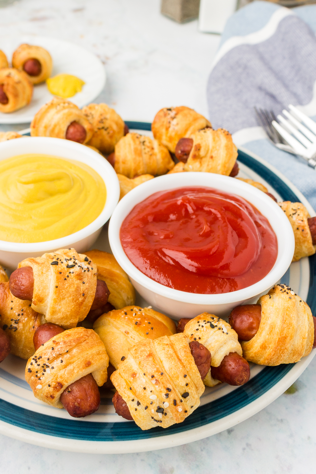 pigs in a blanket on a plate with dipping sauces