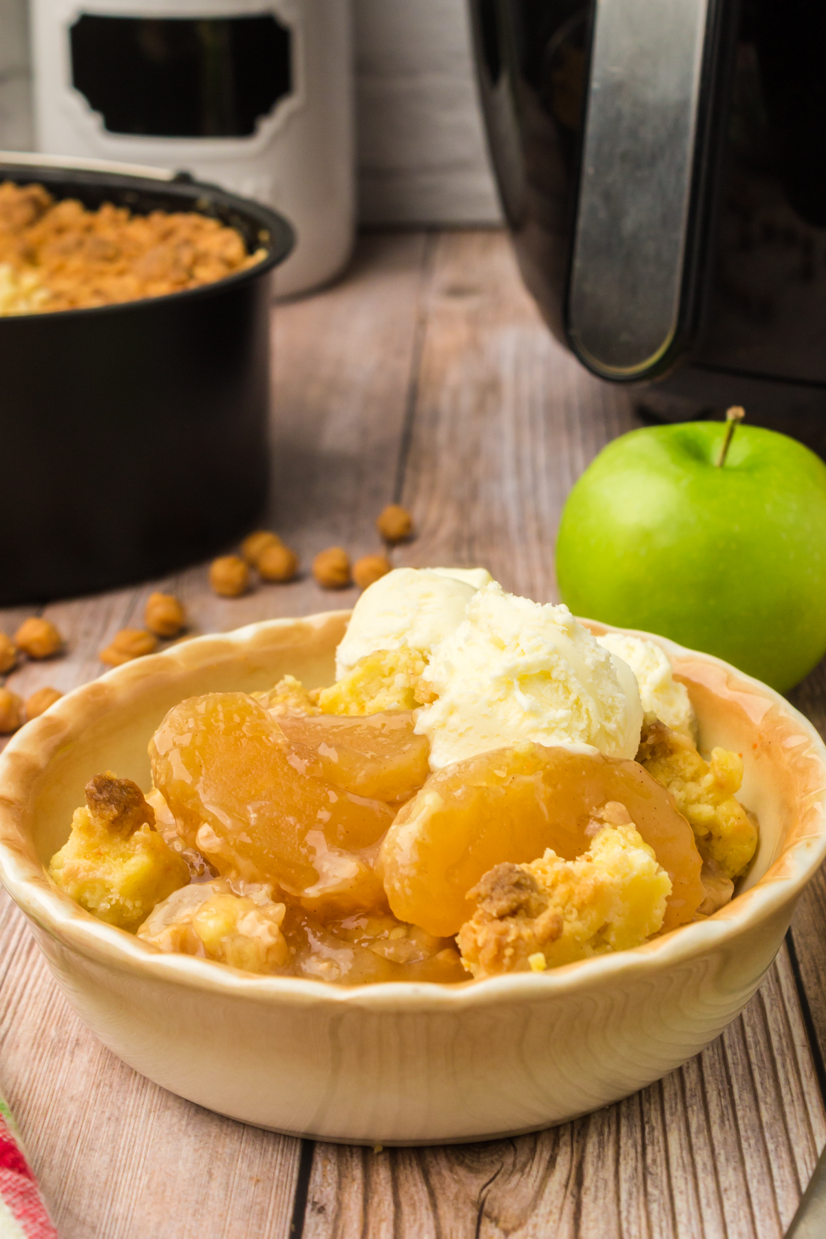 Air Fryer Caramel Apple Pie Filling Dump Cake in a bowl with ice cream